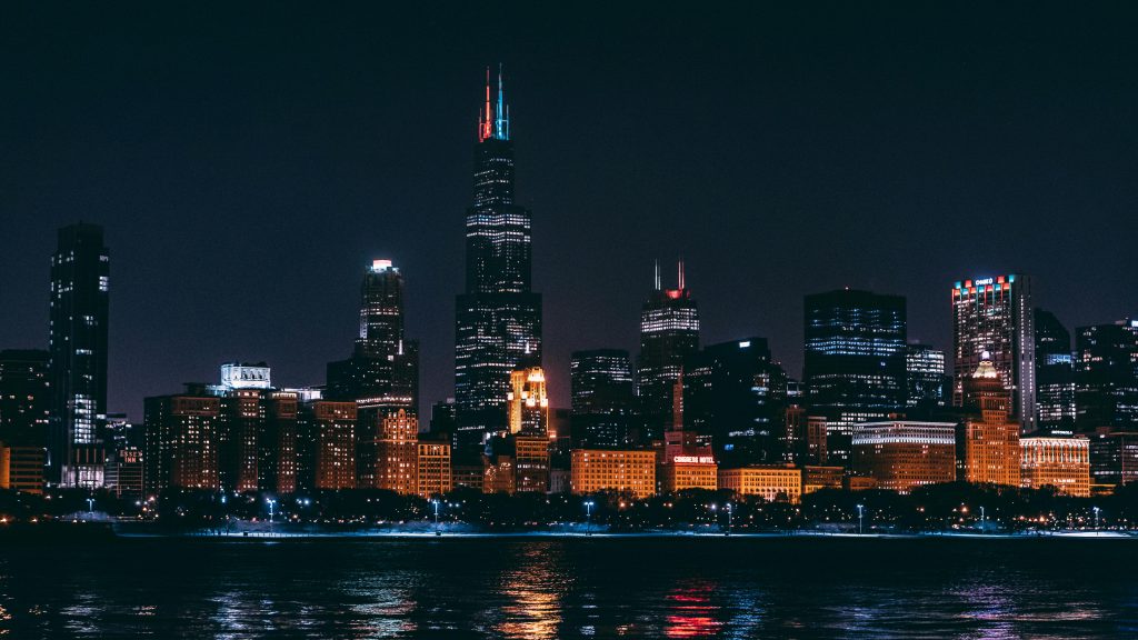 Stunning night view of Chicago skyline highlighting illuminated skyscrapers across the water.